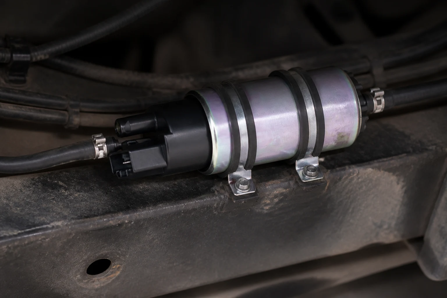 Electric fuel pump clamped to a chassis frame rail with rubber-insulated mounting bands
